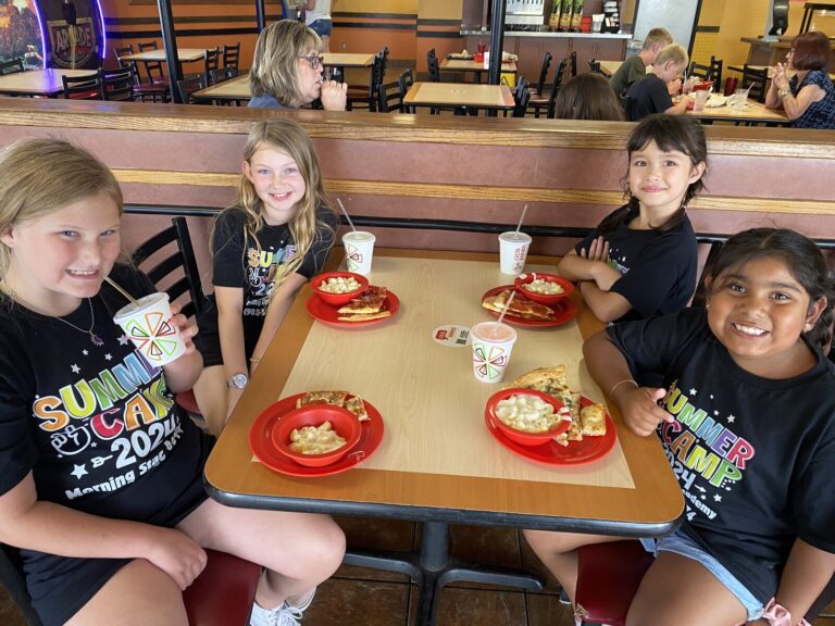 Four students eat out at a pizza buffet during a school trip